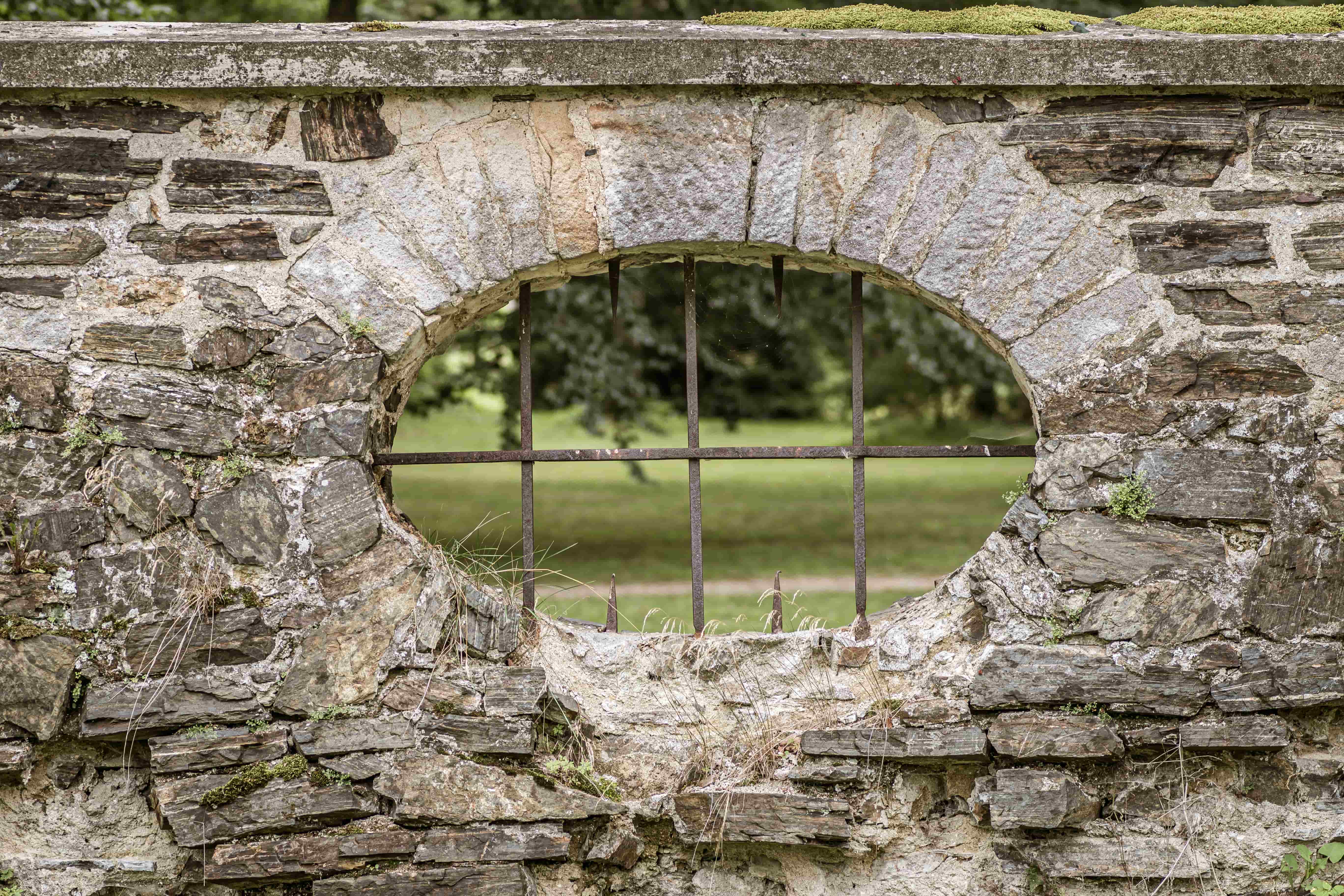 Stonework fence with an opening with iron bars